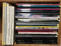 Boxed collection of contemporary art auction catalogues stacked flat and upright, showing various spines from Christie's and Sotheby's.
