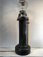 Full view of the vintage candy machine showing base and top with coin mechanism.