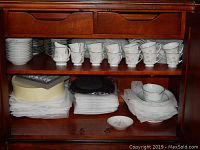 Shelf display of stacked bowls, tea cups, and saucers in Noritake Summerfield pattern china.