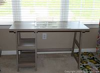Front view of driftwood color veneer desk with two shelves on left side, showing desktop surface and storage.