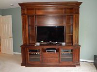 Front view of Ethan Allen entertainment center with TV and shelving.