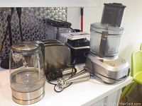 Wide shot of kettle, toaster, food processor, immersion blender and Ninja blender containers.