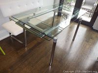 Full view of table extended showing glass top and metal legs