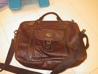 Brown Fossil laptop bag front view showing buckle pocket and handles