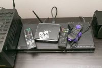 Sony Blu-ray player on a shelf with M10 OTT box and three remote controls on top.