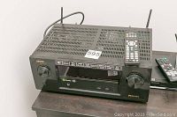 Denon AVR-X2100W with remote control on top, unit on table