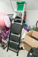 Photo showing two ladders side by side against a cluttered background, Werner aluminum stepladder is in the back, Easy Reach 3-step ladder in front