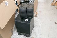 Three Energy brand speakers: two bookshelf speakers and one subwoofer on bubble wrap with cardboard boxes nearby