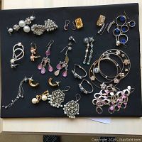 Assorted pierced earrings displayed on black board
