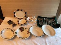 Overview of 6 ceramic bowls, 1 serving platter, 4 ceramic serving bowls, 6 metal napkin rings, and 2 ceramic gravy boats.