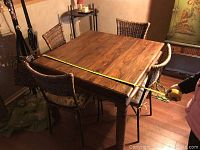 Photo showing top view of square wooden dining table with tape measure indicating 38 inches.