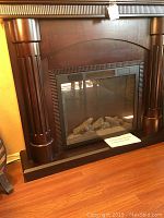 Front view of dark brown mantel and electric insert without flame effect