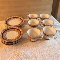 Photo showing 6 delicate china tea cups with gold and red detailing alongside 6 matching dessert plates.