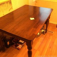 Top view of wooden kitchen table showing smooth polished surface and turned legs.