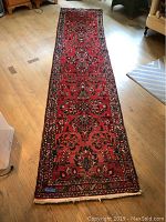 Full-length view of red floral runner on wood floor