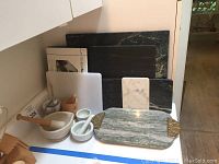 Photo showing multiple mortar and pestle sets and various stone cutting boards including marble, granite, and slate.