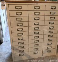 Front view of first metal cabinet showing 33 drawers and cork top