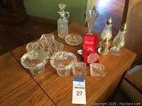 Photo showing entire collection spread on wooden surface, including oil jug, sugar bowls, vase, salt and pepper shakers, ashtrays, candy dish, ornament in box