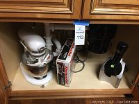 Under-cabinet view of all items: mixer, boxed pouring shield, slicer