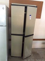 Closed beige plastic storage cabinet with navy blue trim, positioned next to a refrigerator.