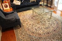 Full view of area rug in living room under glass coffee table and sofa