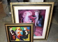 Two framed Linda Le Kinff prints displayed leaning against wall