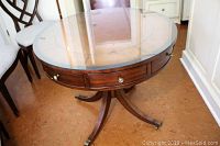 Round table front view showing pedestal base with four legs, removable glass top