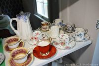 Overall view of Shelley Dainty Blue hot water pot at rear and assortment of demitasse cups and saucers on shelf