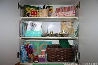 Shelves of assorted craft and painting supplies including Crayola crayons, markers, gift bags, greeting cards, and decorative rocks.