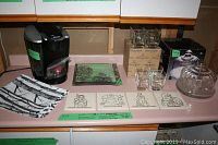 Keurig coffee maker with 2 reusable pods, glass plates, water glasses, placemats, and coasters on counter