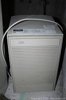 Front view showing the full unit with attached power cord coiled on top.