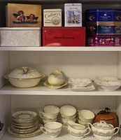 Shelf with assorted vintage decorative cookie tins of various sizes and designs
