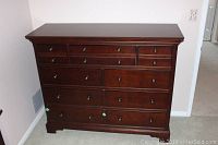 Full front view of the nine drawer dresser in dark wood finish, showing all drawers and round metal knobs.