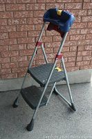 Stepstool standing open viewed at an angle showing steps, frame, and top tray.