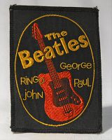Front view of the rectangular black fabric patch with red guitar and yellow embroidered text of The Beatles and member names.