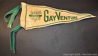 Fabric pennant with green trim and green "Gay Venture" text, featuring a green logo of camping scene.