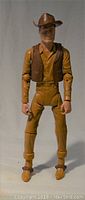 Front view of Johnny West action figure showing articulated joints, wearing brown vest and cowboy hat.