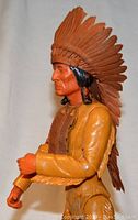 Side profile of Johnny West Indian action figure wearing feathered headdress, showing facial detail and costume.