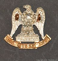 Rear view of the Royal Scots Grey Waterloo military badge showing the two hook fasteners used for attachment.
