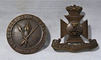 Two badges: one Crossed Torches with King's Crown and 'THE WILTSHIRE REGIMENT' inscription, the other a King's Crown over a cross with banner reading 'THE WILTSHIRE REGIMENT'