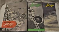 Three vintage Jet Age magazines spread out showing cover art with aircraft and nature themes.