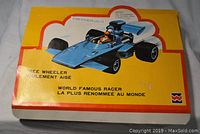 Original yellow box with vintage blue race car image and some damage visible on box edges