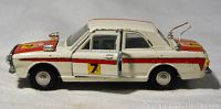 Side view of white and red Meccano Dinky Toys Ford Cortina diecast car showing racing number 7 decal on door, antennas on rear, and condition with paint wear.