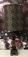 Lamp with dark paisley pattern lampshade shown against floral background