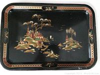 Full view of rectangular metal tray with black background and detailed painted scenic artwork depicting buildings, trees, and water in muted colors