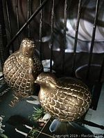 Pair of two brass quail figures placed together showing textured feather detail and body shape