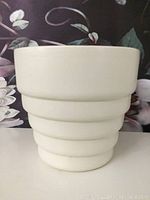 Front view of the tall off-white vintage Haeger pot with stepped exterior design.