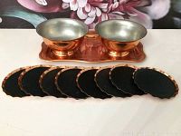 Set showing two copper bowls on copper tray and eight copper coasters arranged in front