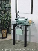Single vanity with black wood legs, tempered glass top, round clear vessel sink and chrome faucet beneath a rectangular mirror with black trim