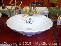 Single white ceramic scalloped-edge vessel sink installed with faucet, showing shape and finish